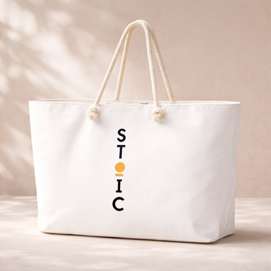 White STOIC tote bag with logo on a beige background