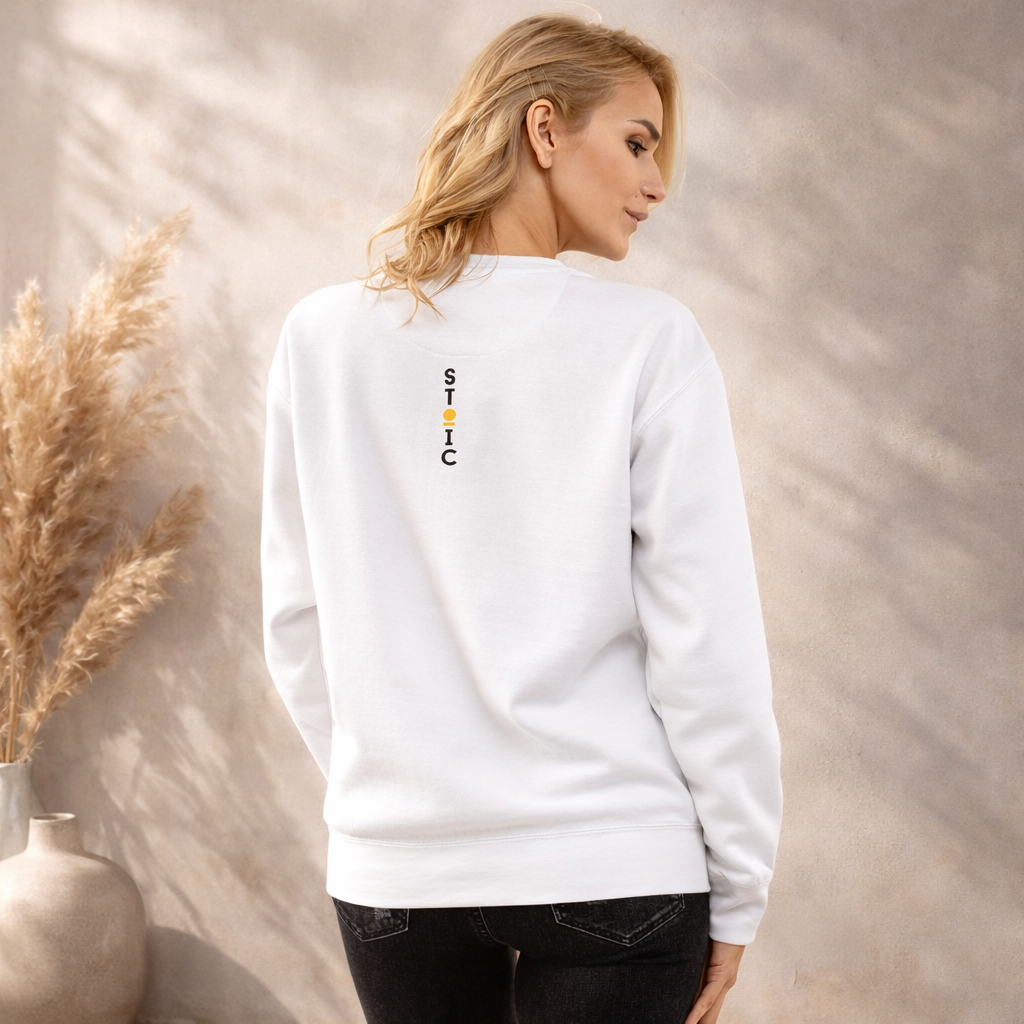 Woman wearing a white STOIC sweatshirt with a logo on the back, standing against a neutral background.