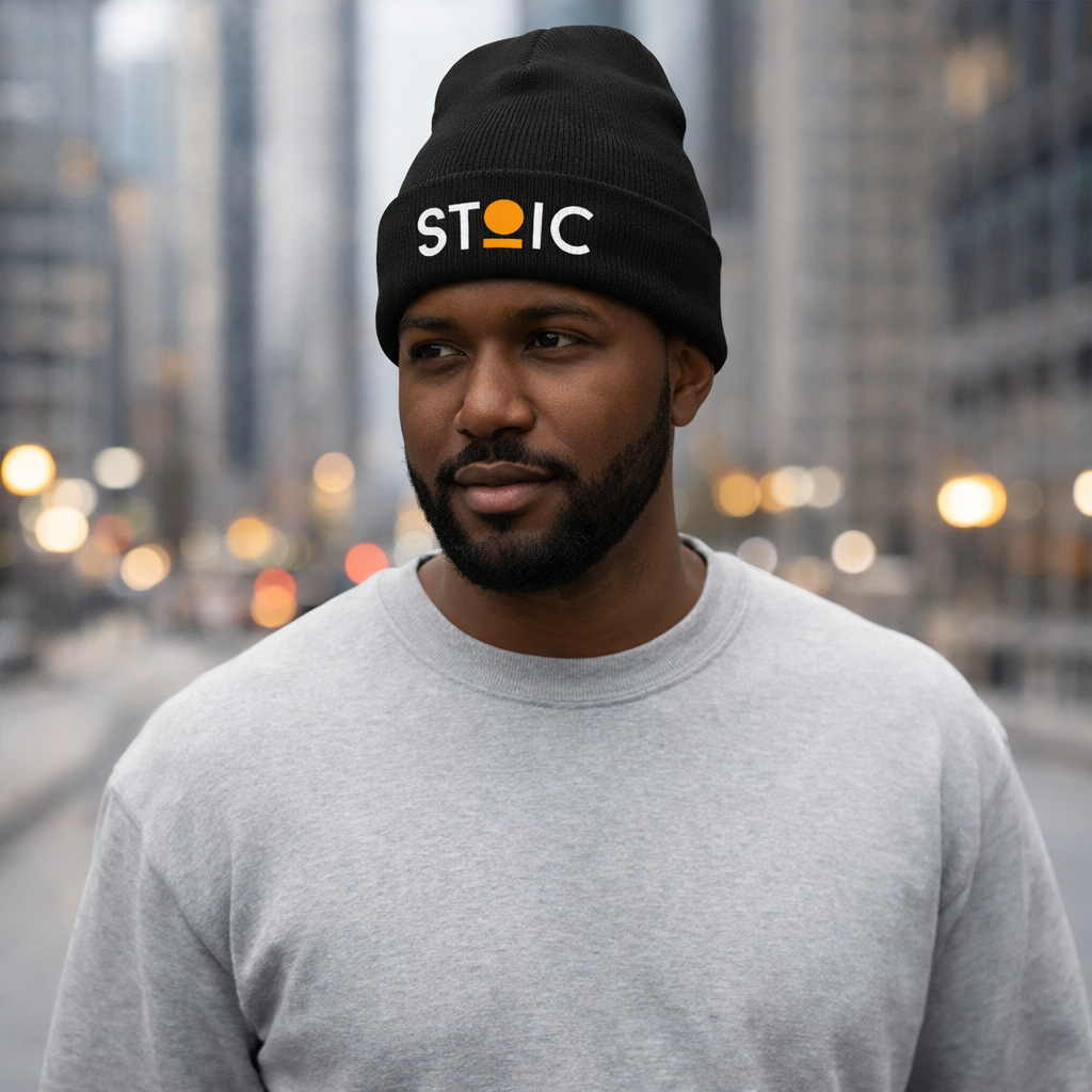 Man wearing a black STOIC beanie with embroidered logo in an urban setting
