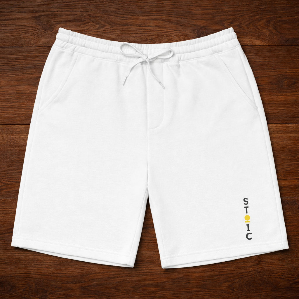 White shorts with a embroidered vertical STOIC logo on a wooden surface