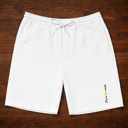 White shorts with a embroidered vertical STOIC logo on a wooden surface
