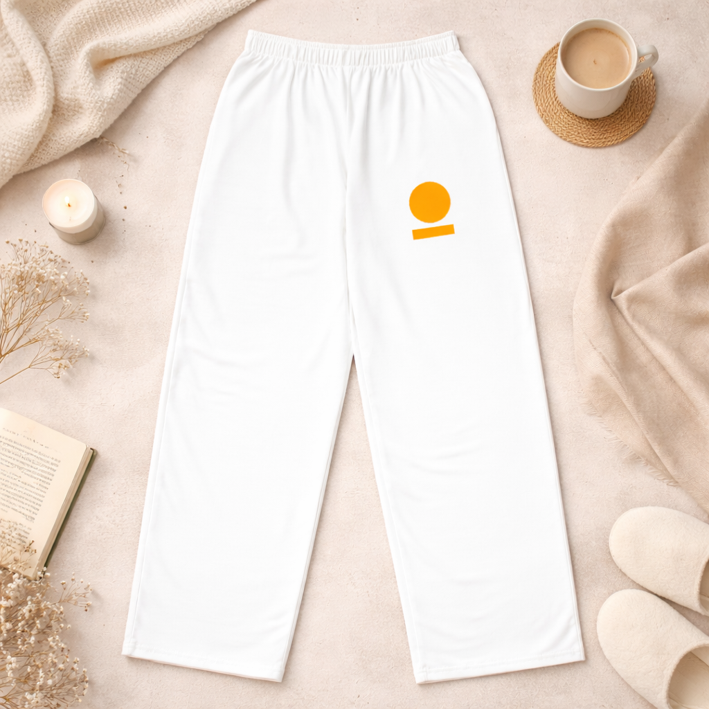 White STOIC pants with logo on front left thigh on a beige surface with a cup and candle.
