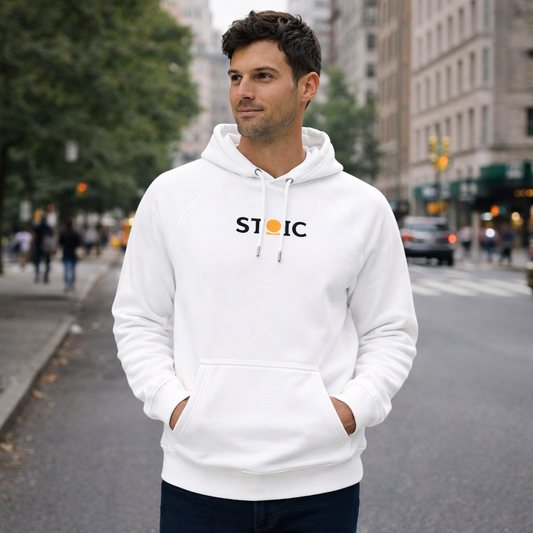 Man wearing a white STOIC hoodie with embroidered 'STOIC' logo on a city street