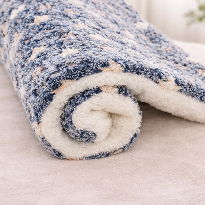 Rolled-up blue and beige patterned fleece Flannel Pet sleeping Mat on a light background