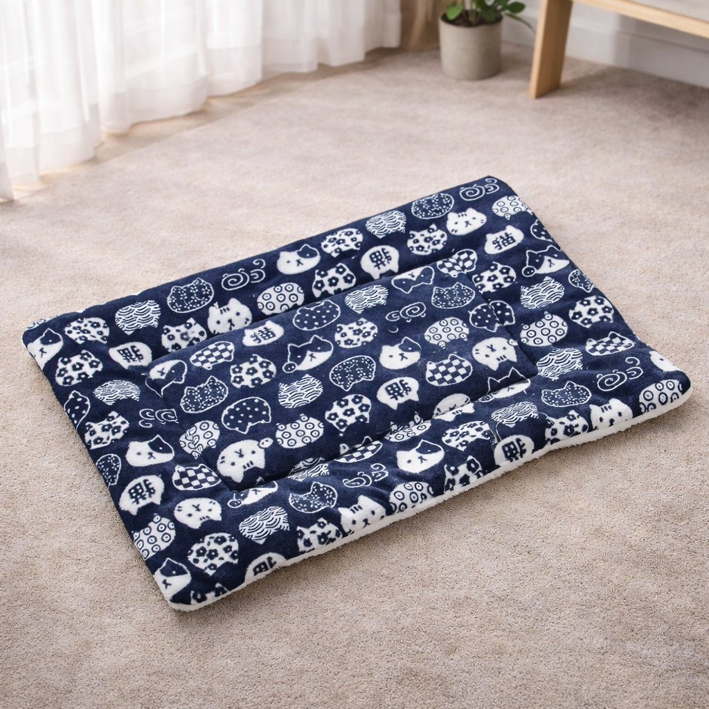 Navy blue pet bed with white animal pattern on a beige carpet