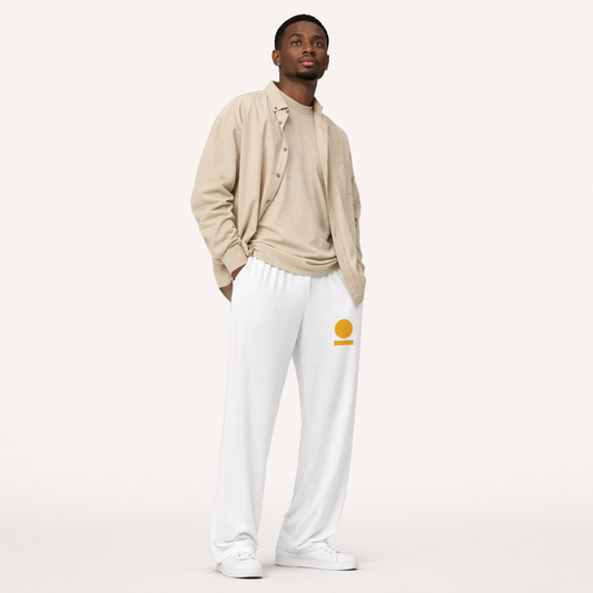 Man wearing a beige cardigan, white STOIC pants with logo on front left thigh, and white sneakers on a white background