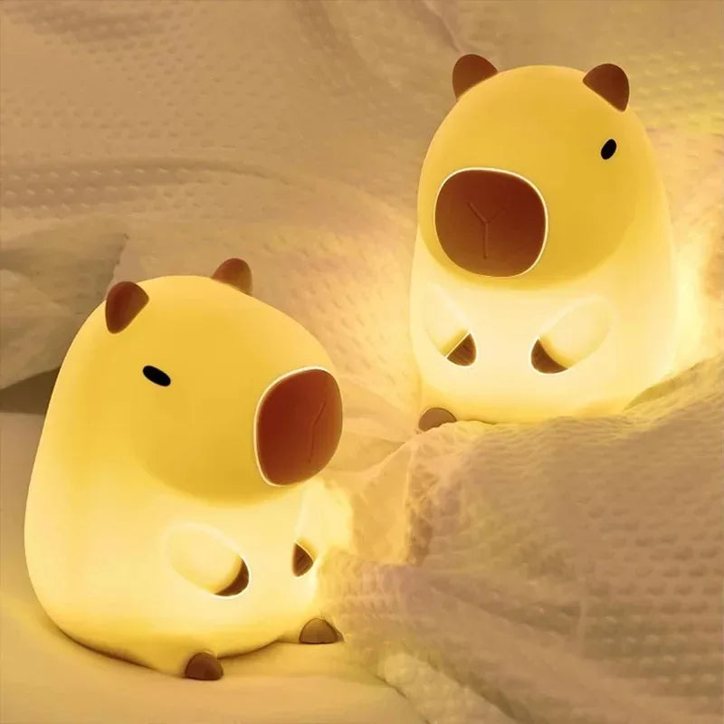 Two yellow animal-shaped night lights on a soft fabric background