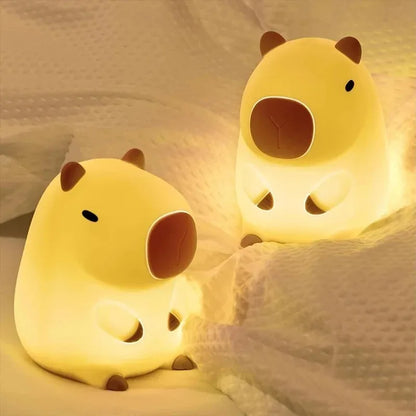 Two yellow animal-shaped night lights on a soft fabric background