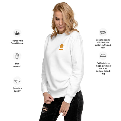 Woman wearing a white STOIC sweatshirt with embroidered logo, standing against a white background with text about sweatshirt features.